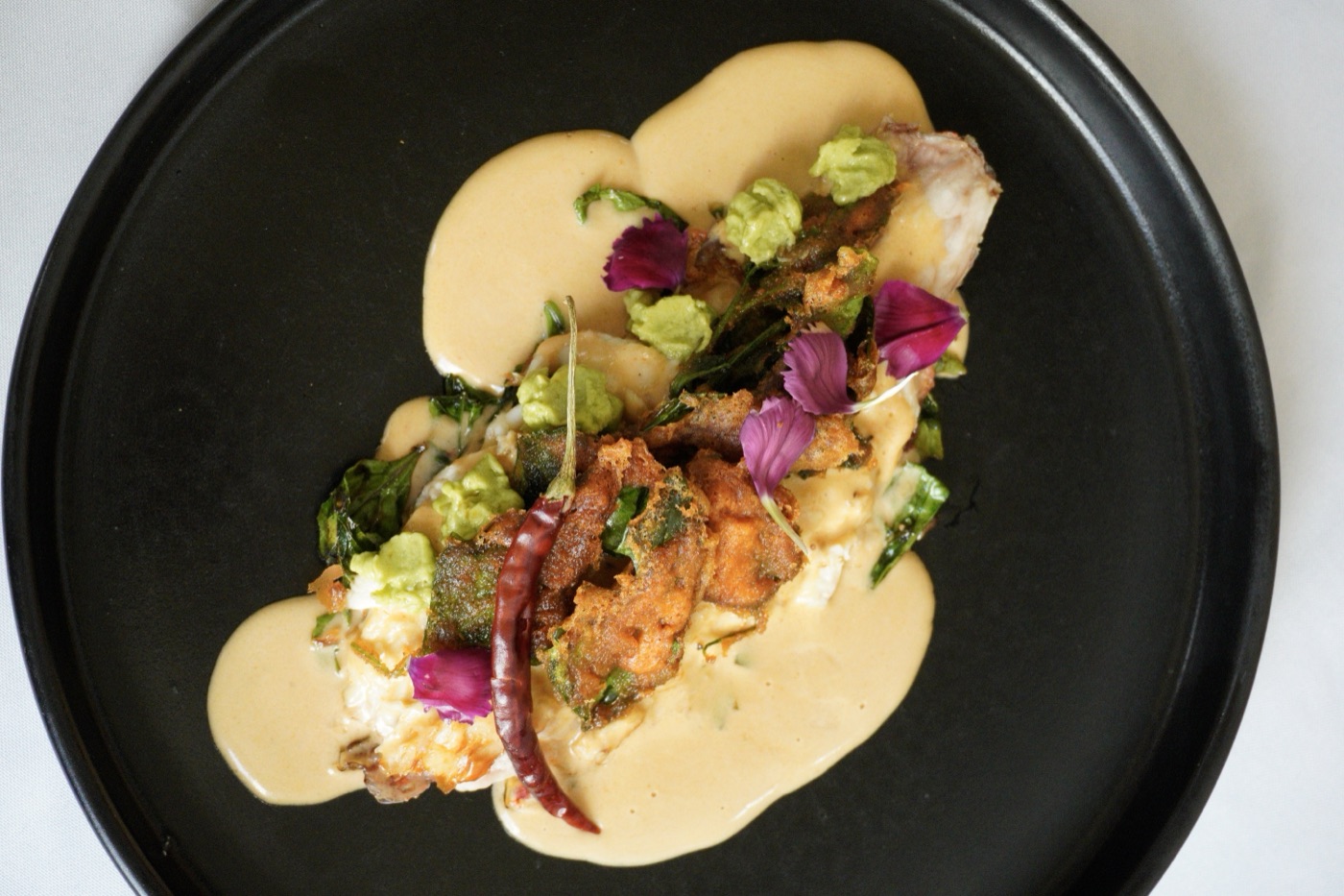 Huachinango con quelites crujientes y aguacate.